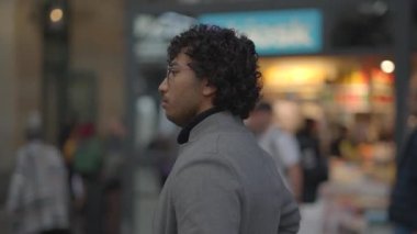 Tren istasyonunda siyah kıvırcık saçlı genç adamın yaşam tarzı portresi. Yüksek kalite 4k görüntü