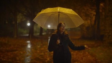 Yağmurlu bir gecede Şemsiyeyle Dans eden Kaygısız Kadın