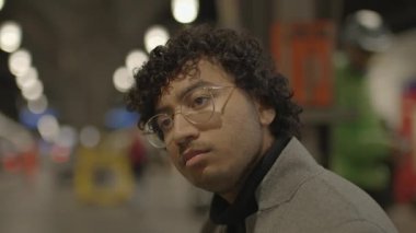 Tren istasyonunda siyah kıvırcık saçlı genç adamın yaşam tarzı portresi. Yüksek kalite 4k görüntü
