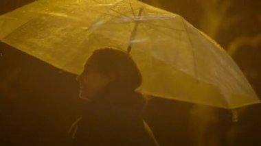 Yağmurlu bir gecede Şemsiyeyle Dans eden Kaygısız Kadın