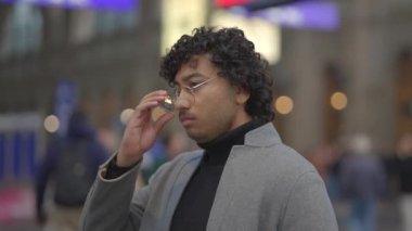 Tren istasyonunda siyah kıvırcık saçlı genç adamın yaşam tarzı portresi. Yüksek kalite 4k görüntü