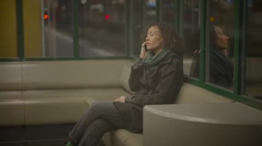 Geceleri şehirdeki kızgın cep telefonuyla konuşan tartışmacı bir kadın.