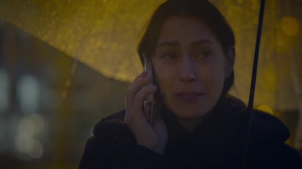 Сумна Жінка Розмовляє Мобільним Телефоном Надворі Вночі Дощову Погоду — стокове відео