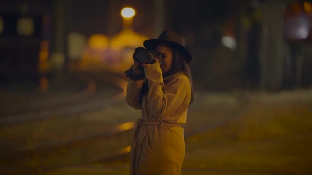 若い女性写真家 夜の光で都市のストリートで写真を撮る — ストック動画