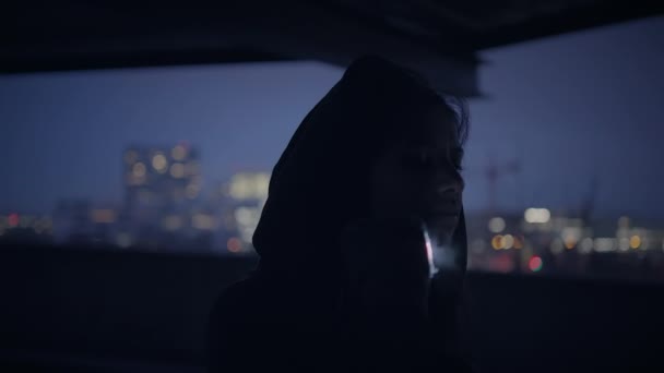 トワイライトライトで放棄された都市街を歩くフード付き恐れのない女性 — ストック動画