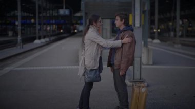 Tren istasyonunda ayrılan iki üzgün insana veda ediyoruz.
