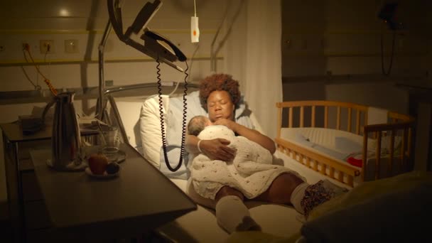 乳幼児と配達室で休むカーリーヘアを持つ黒人女性 — ストック動画