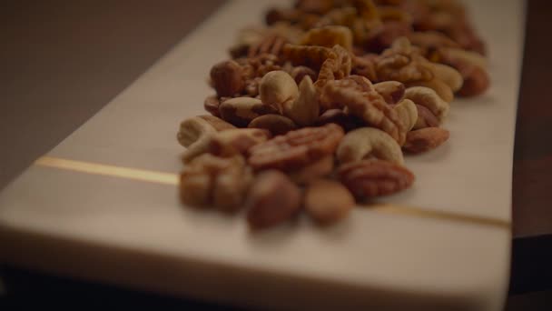 木のテーブルのアルモンドの混合されたナッツ ペカン ウォルナッツのカシュー ヘーゼルナッツ — ストック動画