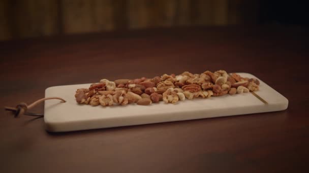 木のテーブルのアルモンドの混合されたナッツ ペカン ウォルナッツのカシュー ヘーゼルナッツ — ストック動画