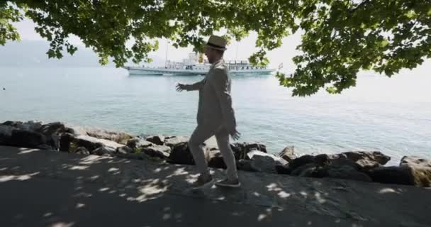 穿着复古风格的无忧无虑的男人走在湖畔的码头上 高质量的4K镜头 — 图库视频影像