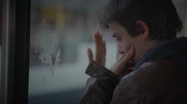 Anne, Oğlu Tren İstasyonu 'nda Bekliyor. Saate danışmak için saati kontrol ediyor.