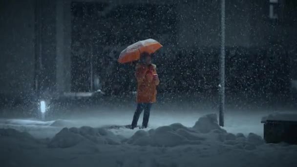 アフリカの若い女性は雨傘で雪が降る夜にストリートに立っている — ストック動画