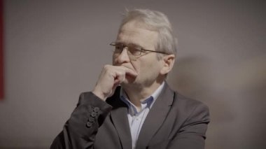 Gri saçlı düşünceli yaşlı beyefendi hayatı düşünüyor.