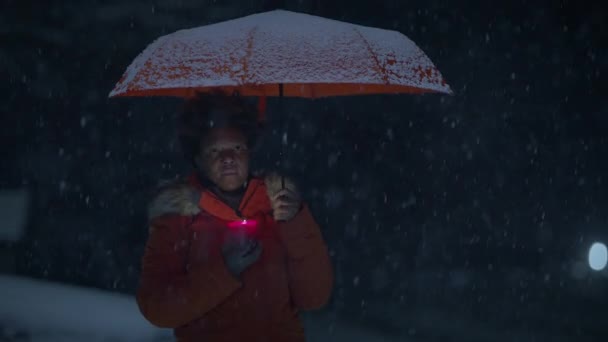 雪の冬の天気でキャンドルライトを保持しているカーリーヘアを持つ黒い女性人 — ストック動画