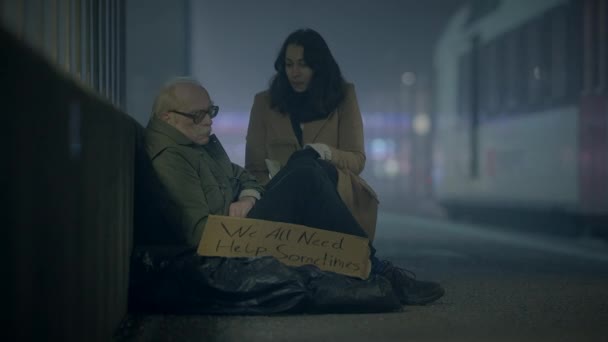 对贫穷的乞丐表现出同情和善意的青年女性 — 图库视频影像