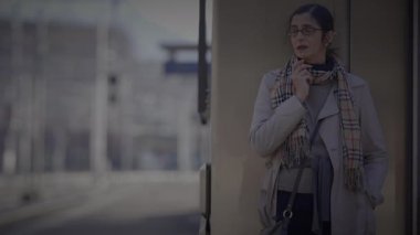 Anne, Oğlu Tren İstasyonu 'nda Bekliyor. Saate danışmak için saati kontrol ediyor.