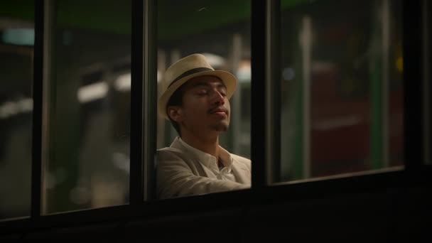 夜の列車駅プラットフォームで一人で待っている若い男 — ストック動画