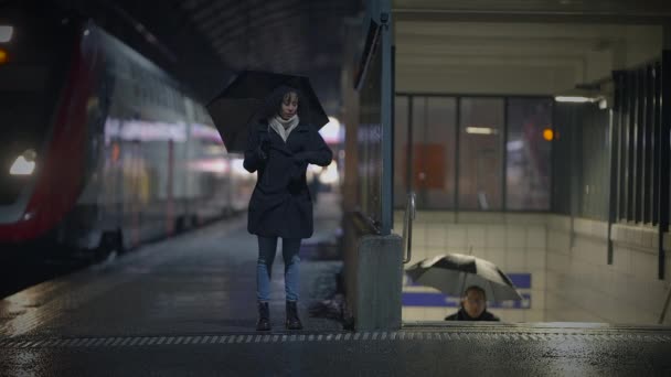 Bir Kadın Elinde Şemsiyeyle Yağmur Altında Tren Istasyonunun Önünde Yürüyor — Stok video