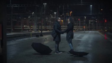 Geceleri tren istasyonunda tartışan kızgın bir çift.