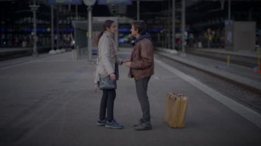 Tren istasyonunda ayrılan iki üzgün insana veda ediyoruz.