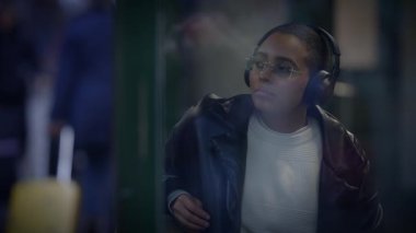 Hayatı düşünen düşünceli bir kadın. Kulaklık takıyor. Müzik dinliyor.