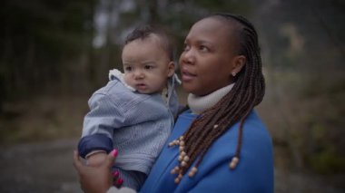 Anne kucağında küçük bebek dışarıda aile hayatının tadını çıkarıyor. 