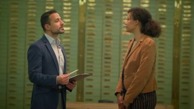 Takım elbiseli bir adam, banka da dahil olmak üzere çeşitli ortamlardaki bir kadınla mali konuları tartışıyor. Çift bir odada sohbet ederken görülüyor ve adam bir konuşma sırasında elinde bir pano tutuyor.