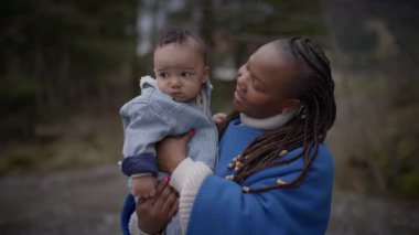 Anne kucağında küçük bebek dışarıda aile hayatının tadını çıkarıyor. 