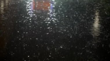 Yağmurlu bir yola yansıyan gece lambaları büyüleyici ve huzurlu bir şehir manzarası yaratıyor..