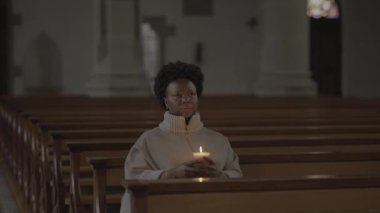 Kilisede dua eden kıvırcık saçlı genç Afrikalı kadın. Yüksek kalite 4k görüntü