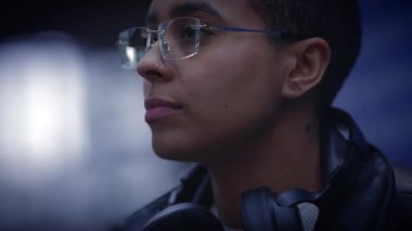 Tren istasyonunda bekleyen genç bir kadın işe gidip gelenleri izliyor. 