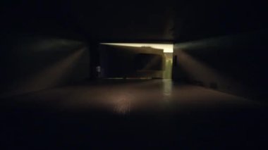 Bir kişinin loş bir alanda kapı aralığından gözetlediğini gösteren video çerçeveleri, bir merak hissi yaratıyor..