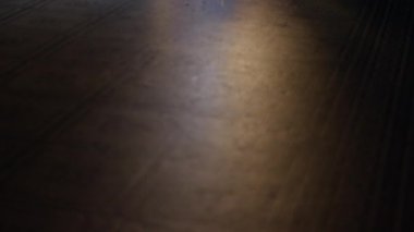 Düşük perspektiften bakıldığında el feneri tutan bir figürün yer aldığı loş bir mahzende karanlık bir koridor.