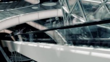 Fütüristik yürüyen merdiven ve cam elementlere sahip şehir binası, dinamik bir alanda modern mimariyi gözler önüne seriyor.