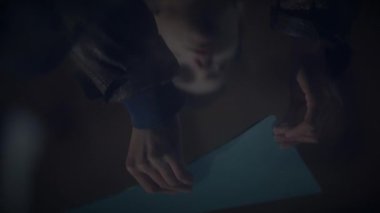 Yumuşak ışıklandırılmış, mavi üçgen şekilli kağıda sıkıca sarılmış, iç gözlem içine daldırılmış şekiller.