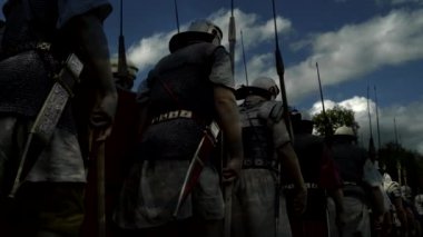 Eski Roma askerleri gibi giyinmiş bir grup aktör ellerinde mızraklarla tarihi bir canlandırmaya katılıyorlar.