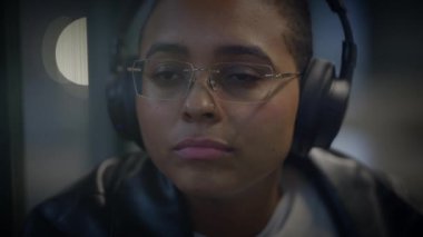 Kulaklık ve gözlük takan, düşünceli görünen ya da müzikten hoşlanan, sükunet ve dinginlik saçan birinin yakın çekimi