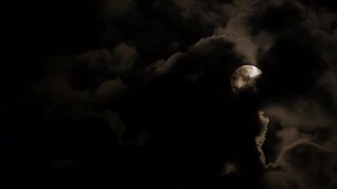 Gece gökyüzü, dolunayın parlaklığını gizleyen karanlık bulutlarla büyüleyicidir. Gizemli bir atmosfer yaratır.