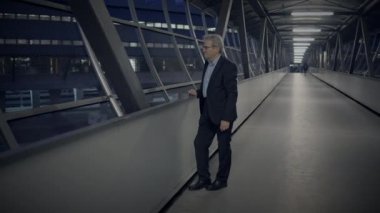 Gece vakti modern bir gökyüzünde yürüyen bir iş adamı, gelecekteki kentsel çevreyle çevrili bir şirket ortamında.