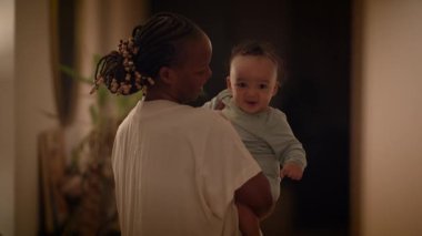 Bir ebeveyn ve bebek sıcak, rahat bir evde, sevgi dolu bir çevrede samimi bir bağ kurarak hassas bir anı paylaşırlar.