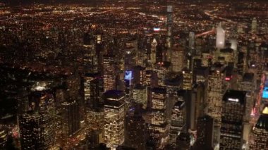 Geceleri New York şehrinin göz kamaştırıcı hava manzarası aydınlanmış gökdelenler ve canlı şehir ışıkları sergileniyor..