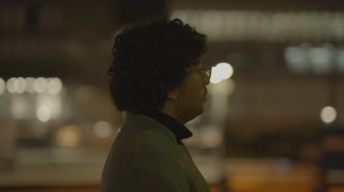 Kıvırcık saçlı ve gözlüklü bir adamın profil görüntüsü.