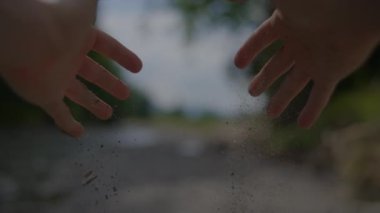Arkasında ağaçlar olan bir nehrin yanında birbirine uzanan iki uzanmış elin bulanık fotoğrafı..