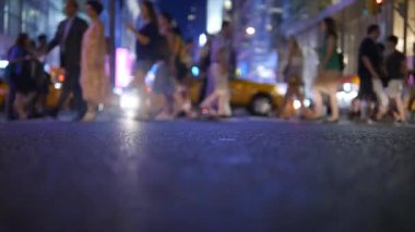 Şehir hayatının bulanık bir gece manzarası. Sokakta yayalar ve arka planda parlak ışıklar..