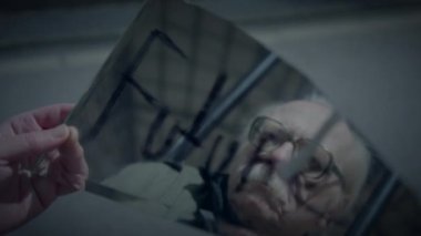 Yaşlı bir adam kırık bir aynada yansımasına bakar, tefekkür ve hatırlama sergiler.