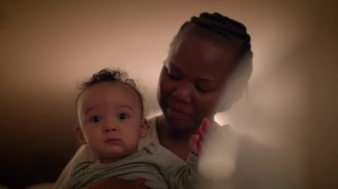 Bir anne sevgiyle bebeğini kucağına alır ve sıcak, yumuşak bir ışık altında hassas bir an yaratır. Duygusal, samimi sahne.