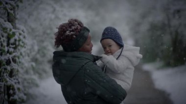 Bir anne ve çocuk, huzurlu kış harikalar diyarında kaynaşan karlı bir ormanda özel bir anı paylaşıyor.