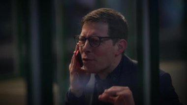 Stresli bir adam ofisteki bir telefon görüşmesinde duygularını gösterir ve iletişim güçlükleriyle karşılaşır.