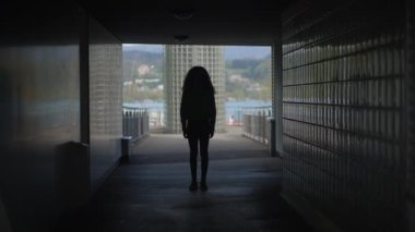 Arka planda manzaralı bir manzarası olan tünelde duran bir kişinin gizemli silueti..