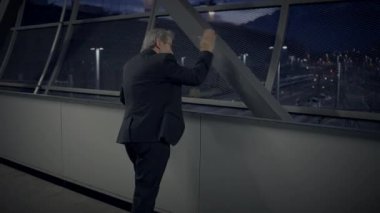 Akşamları bir havaalanı terminalinde duran bir işadamı, yaklaşan seyahatleri hakkında düşüncelere dalmış.